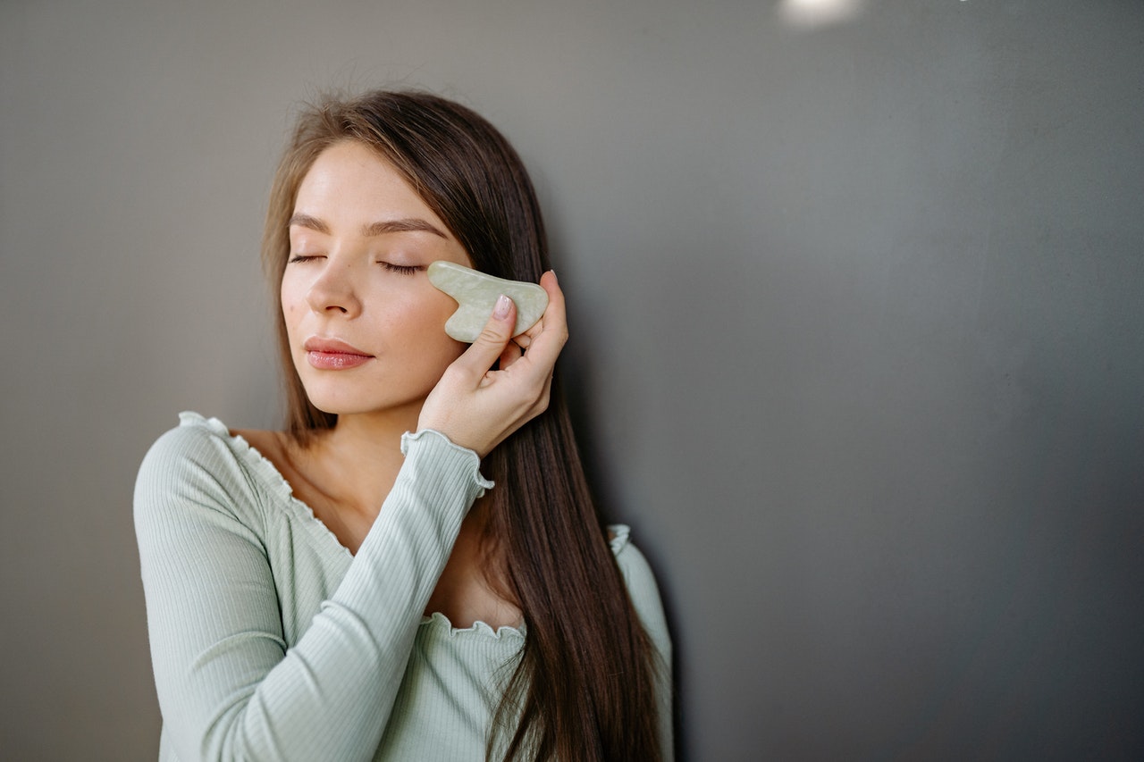 Girl doing Facial Massage with Gua Sha